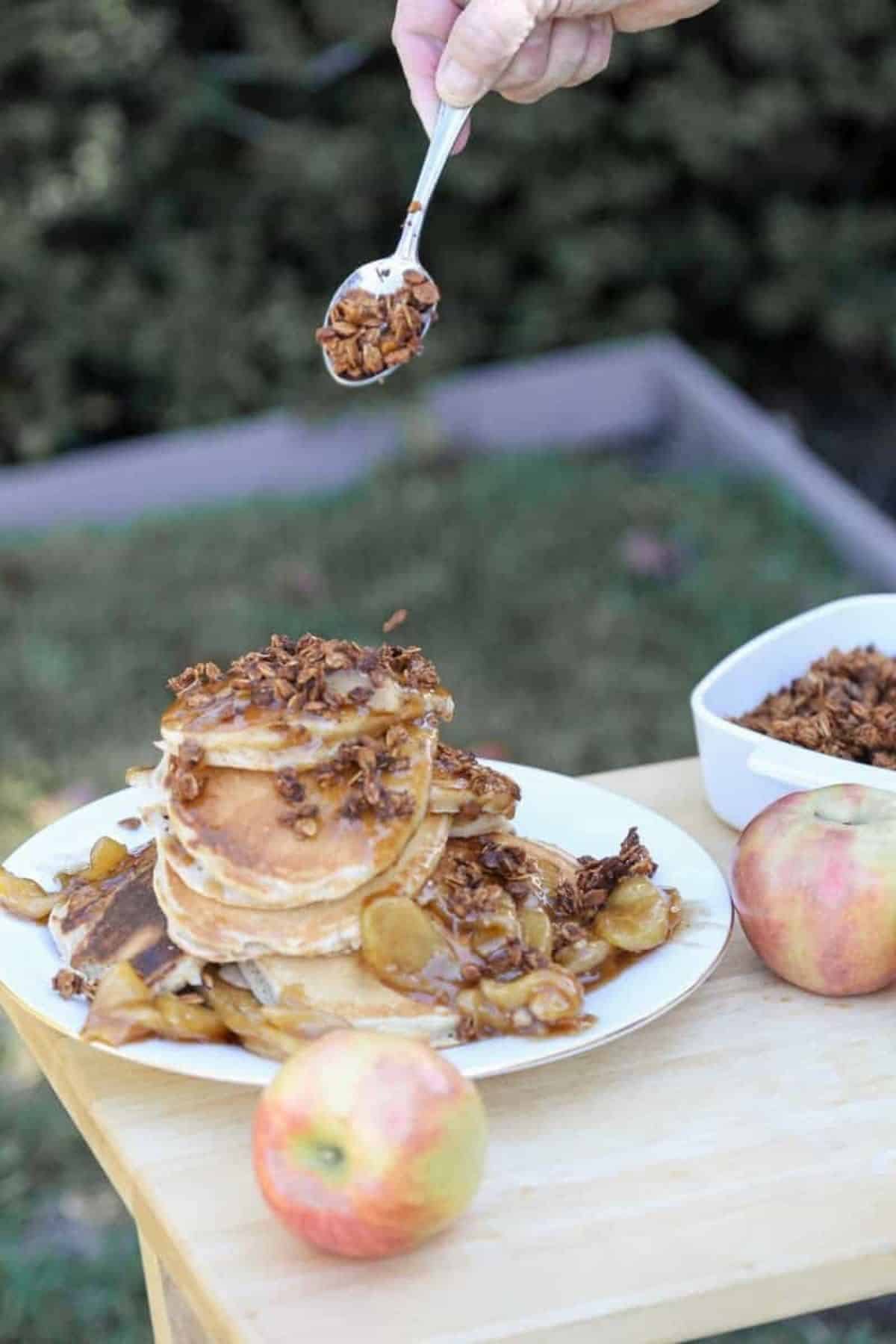 apple granola pancakes with granola on a spoon