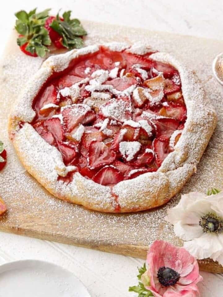 strawberry rhubarb galette being dusted with powdered sugar