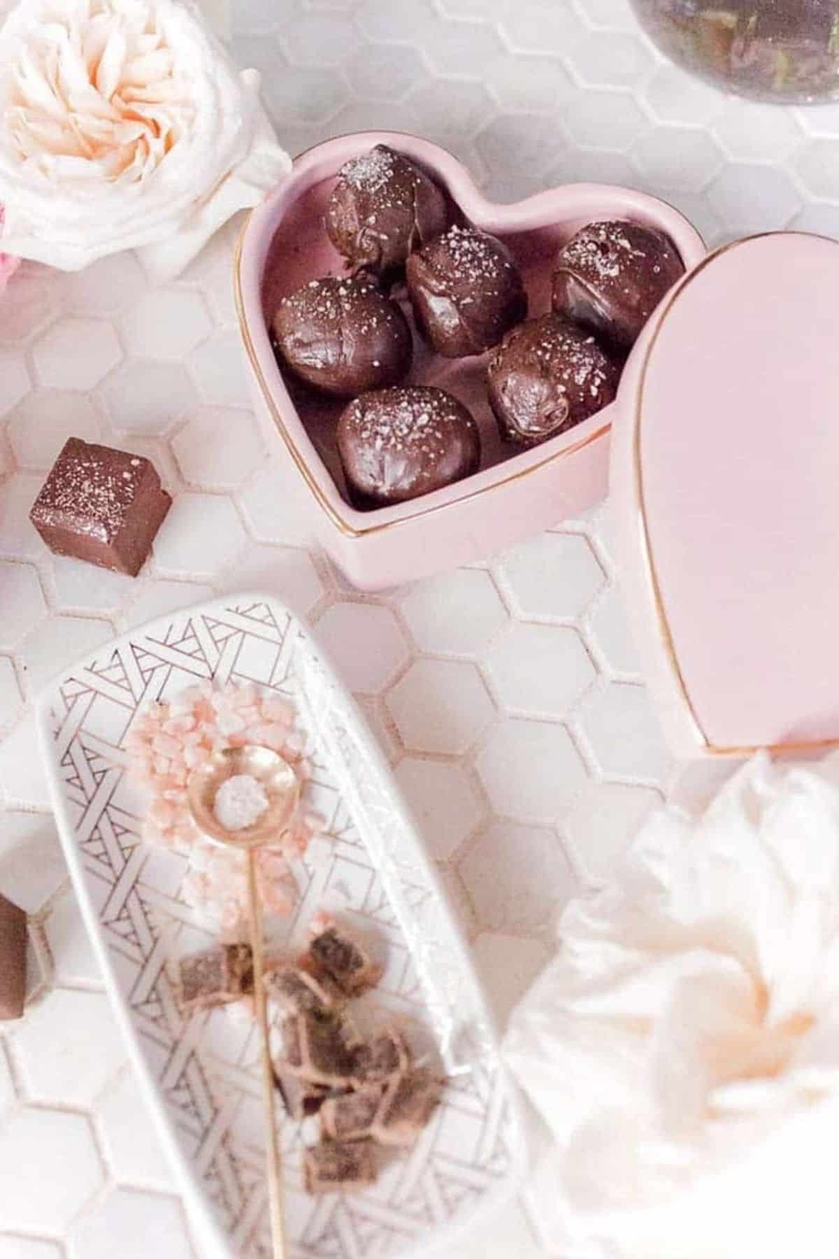 salted dark chocolate truffles in a heart shaped box on a table