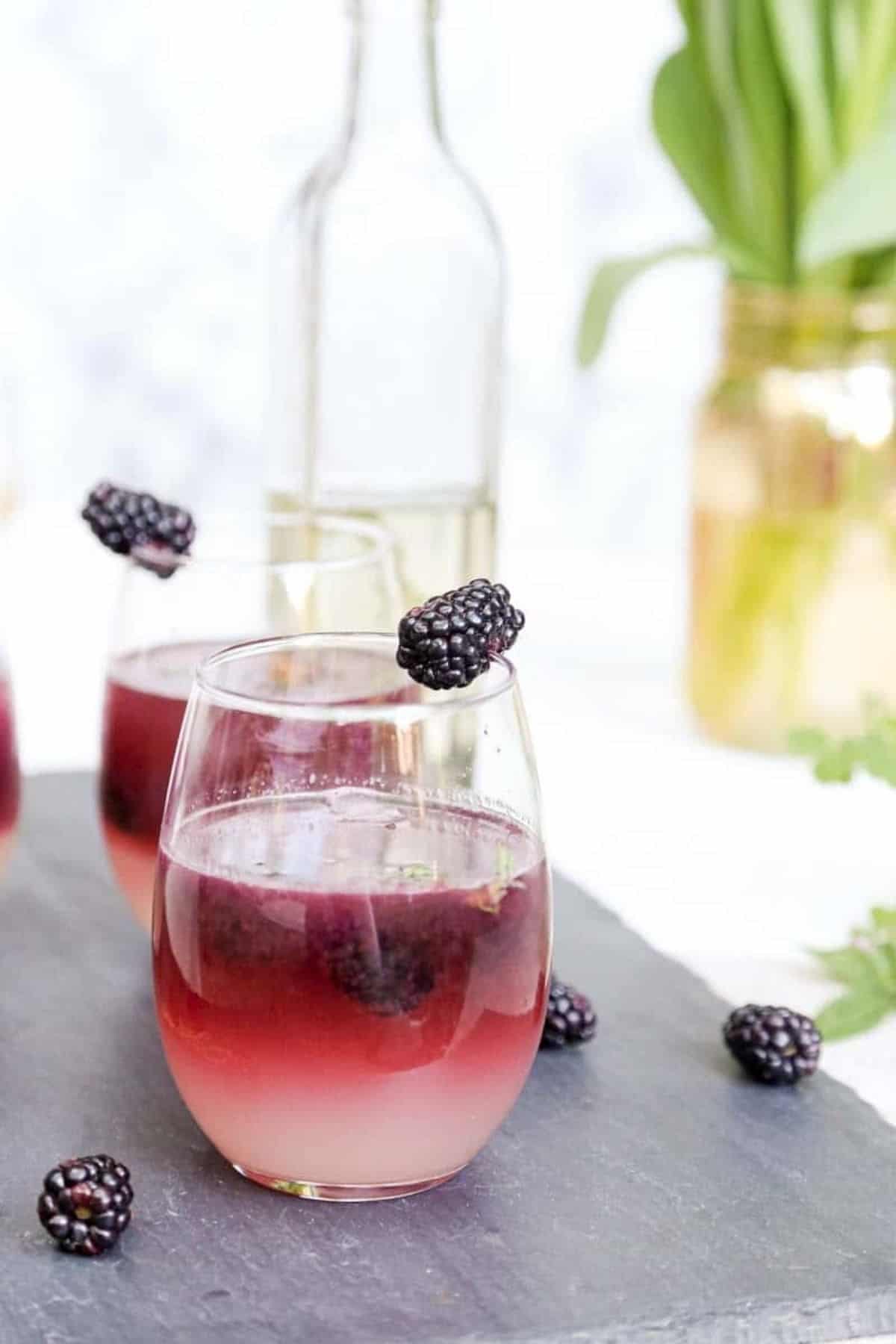 blackberry thyme lemonades with syrup in the back