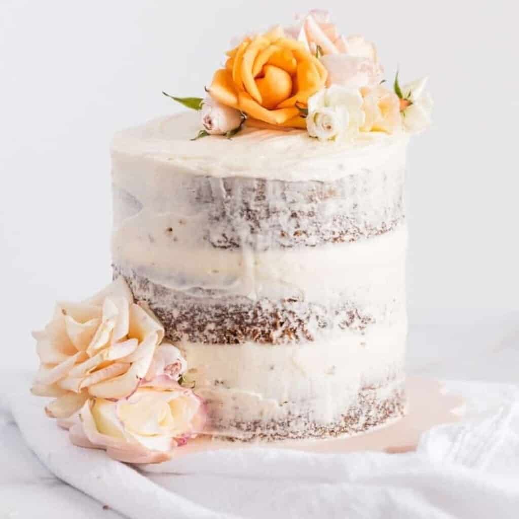 carrot cake with applesauce stacked in three layers and topped with flowers