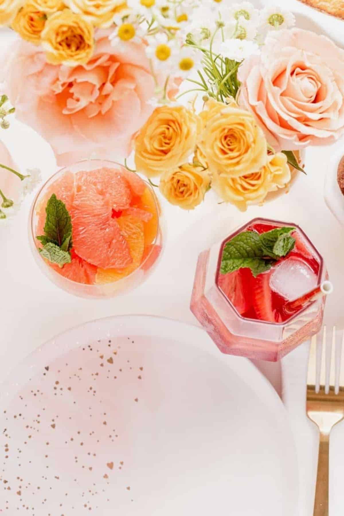 citrus fruit cup next to a strawberry beverage.