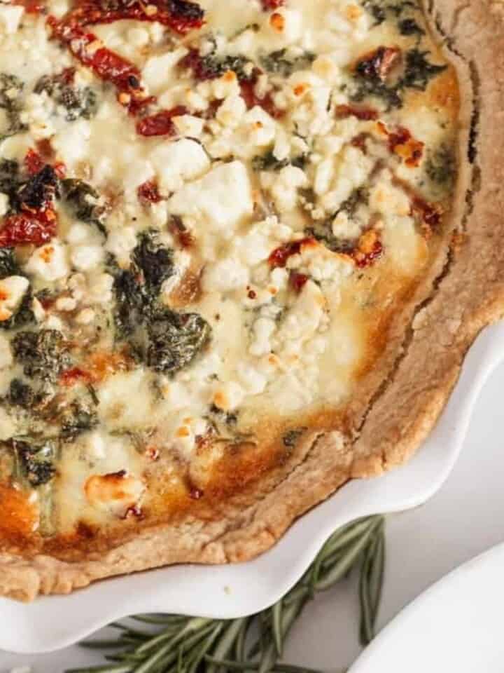 kale and sundried tomato quiche next to a plate