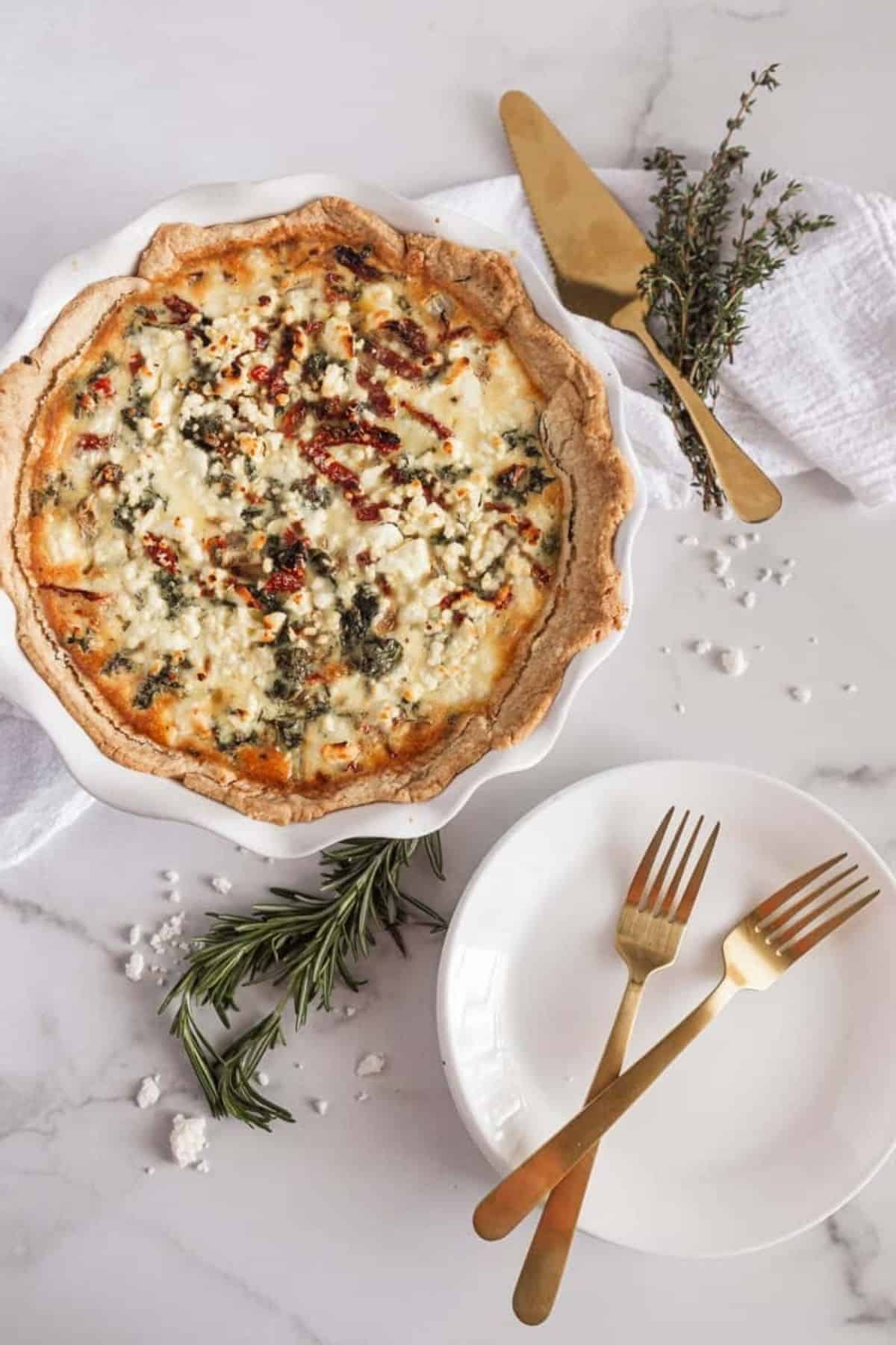 kale and sundried tomato quiche next to a plate