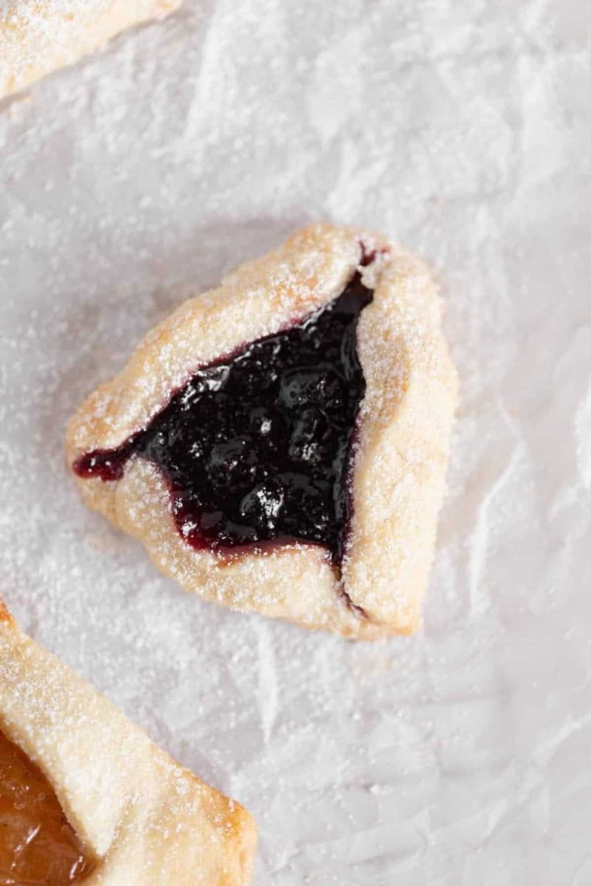close up on hamantaschen with blueberry jam