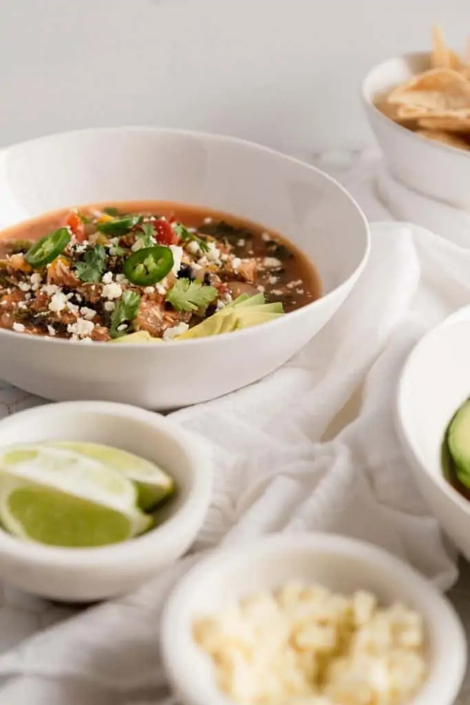 tortilla soup peaking out behind a bowl of limes