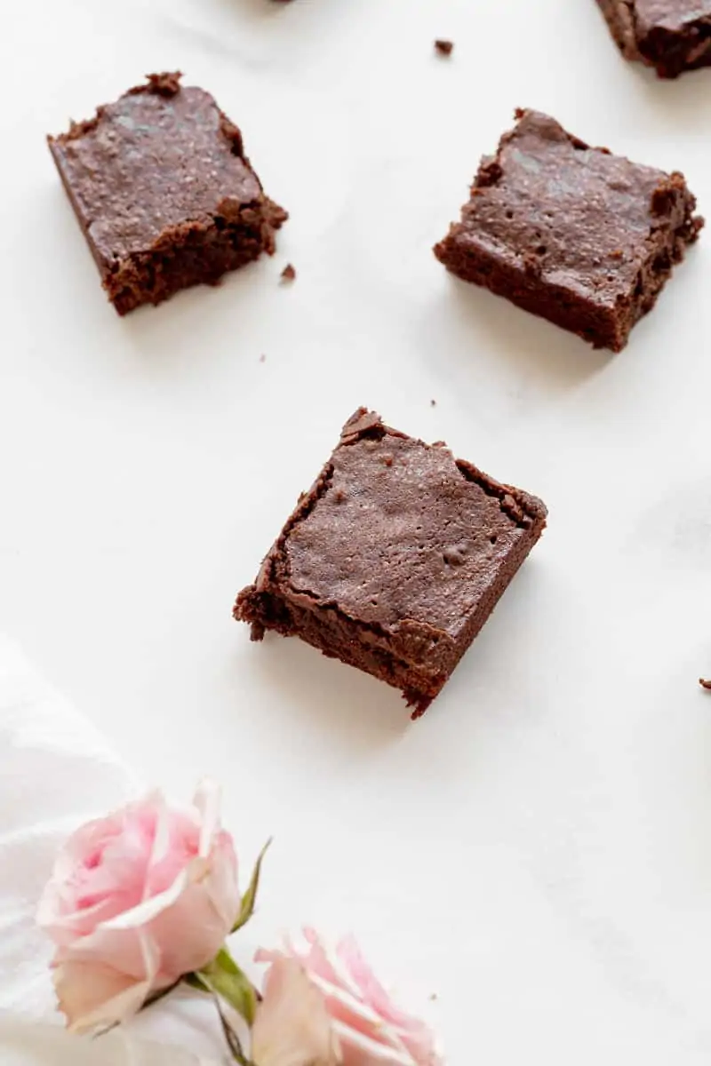 chewy brownies on marble with flowers
