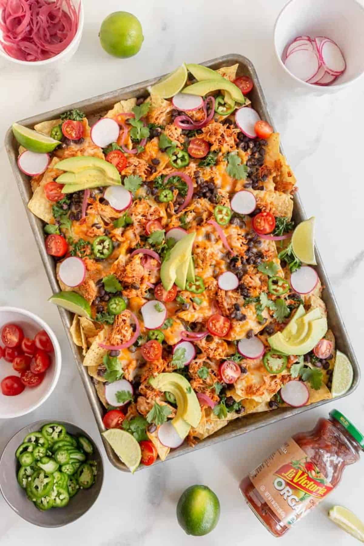 fully loaded nachos on pan with toppings