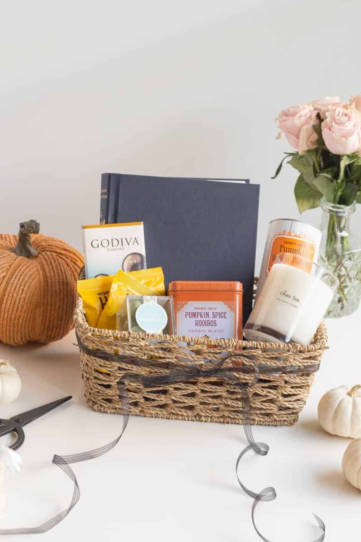 boo basket with wine, candle, blanket, glasses, and kitchen towel