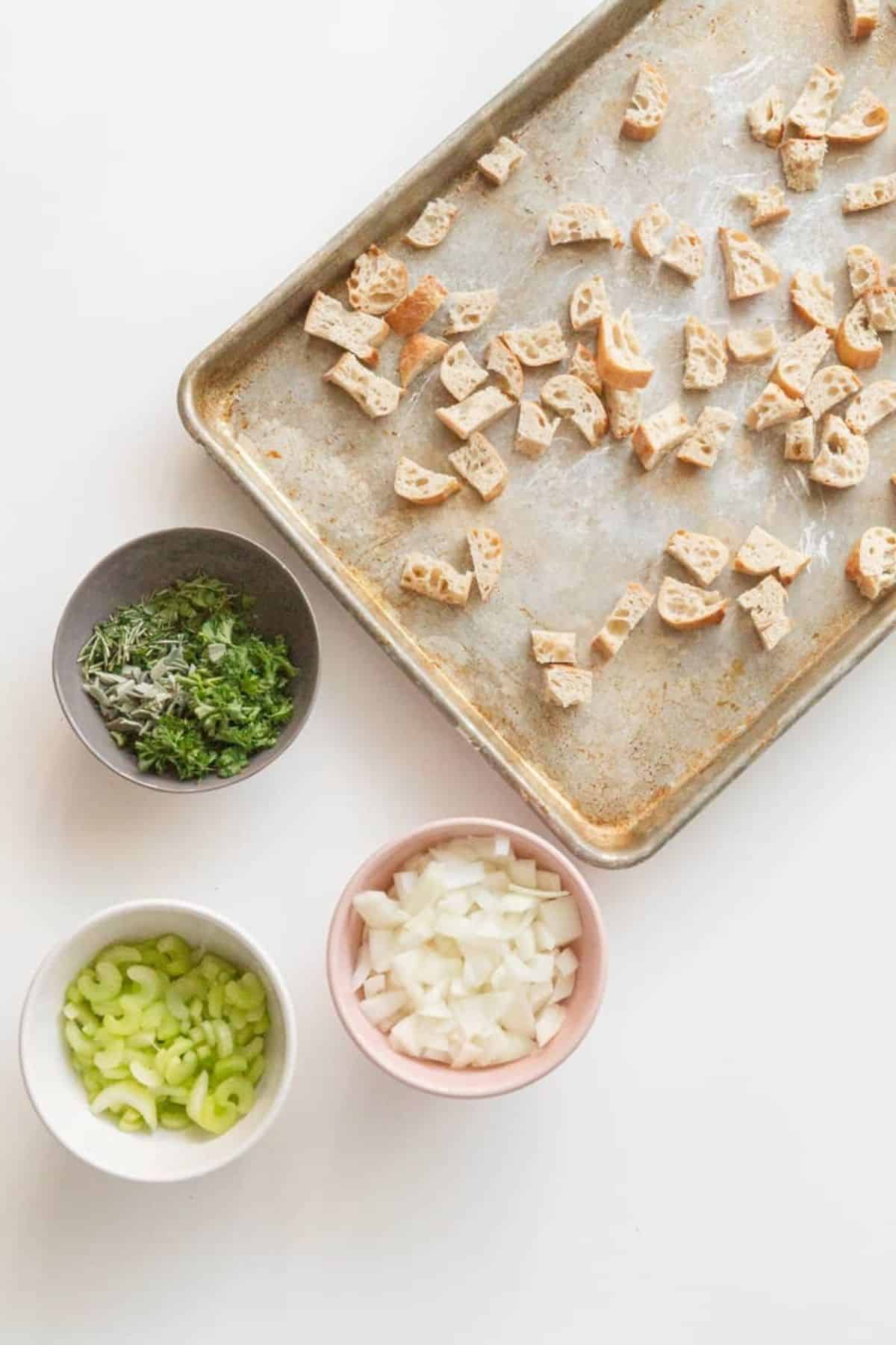 bread on sheet pan and herbs in bowls