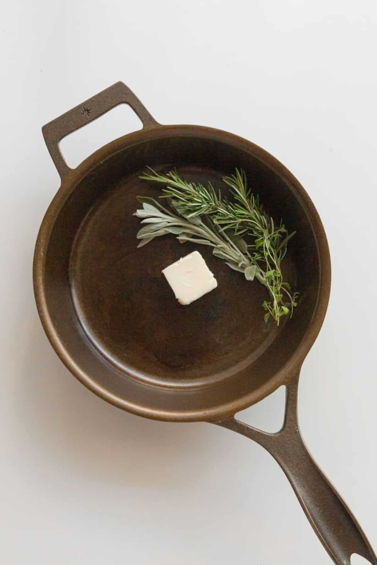 butter and herbs in cast iron skillet