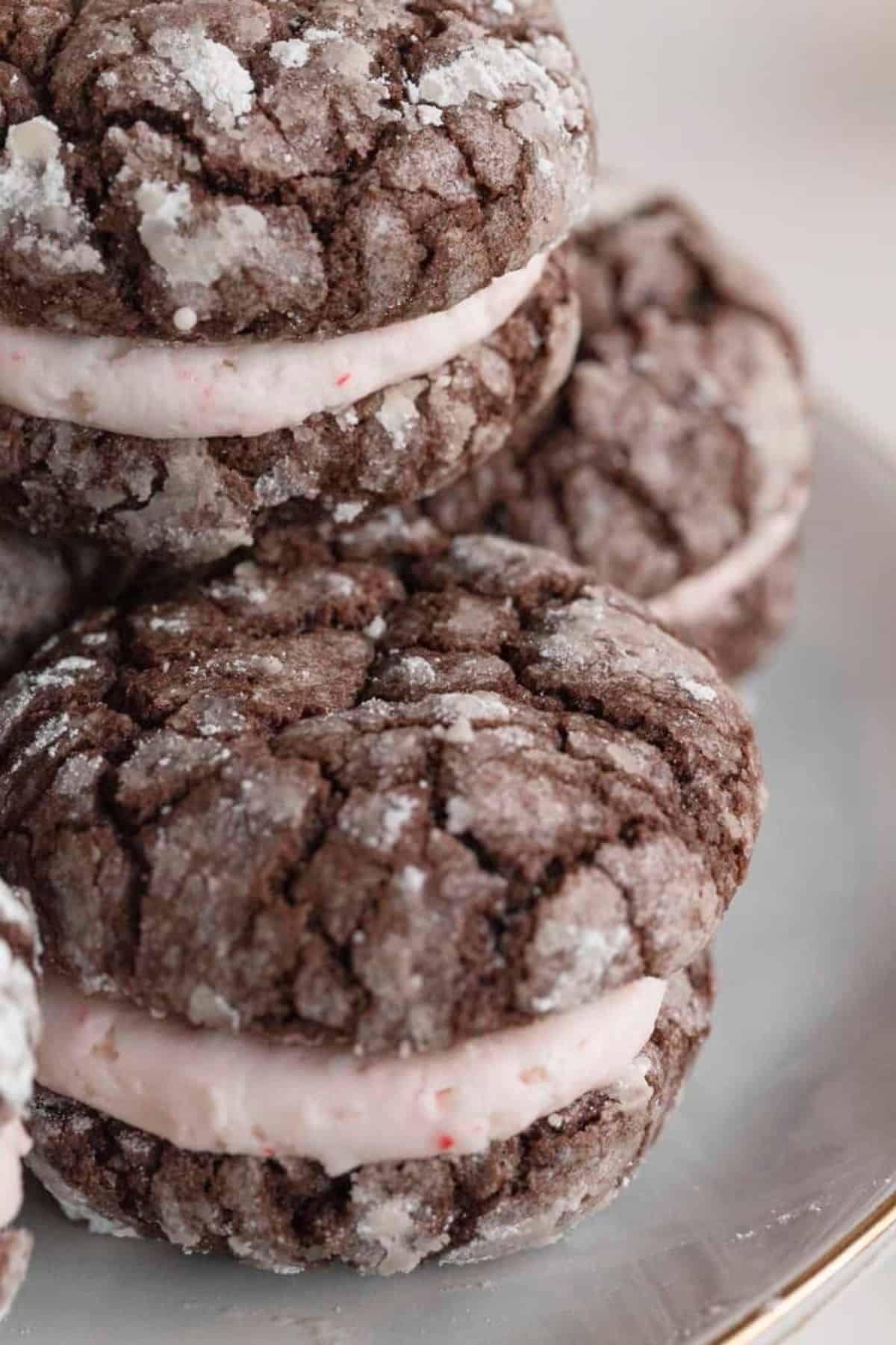 Chocolate crinkle cookies with peppermint buttercream filling on plate close up