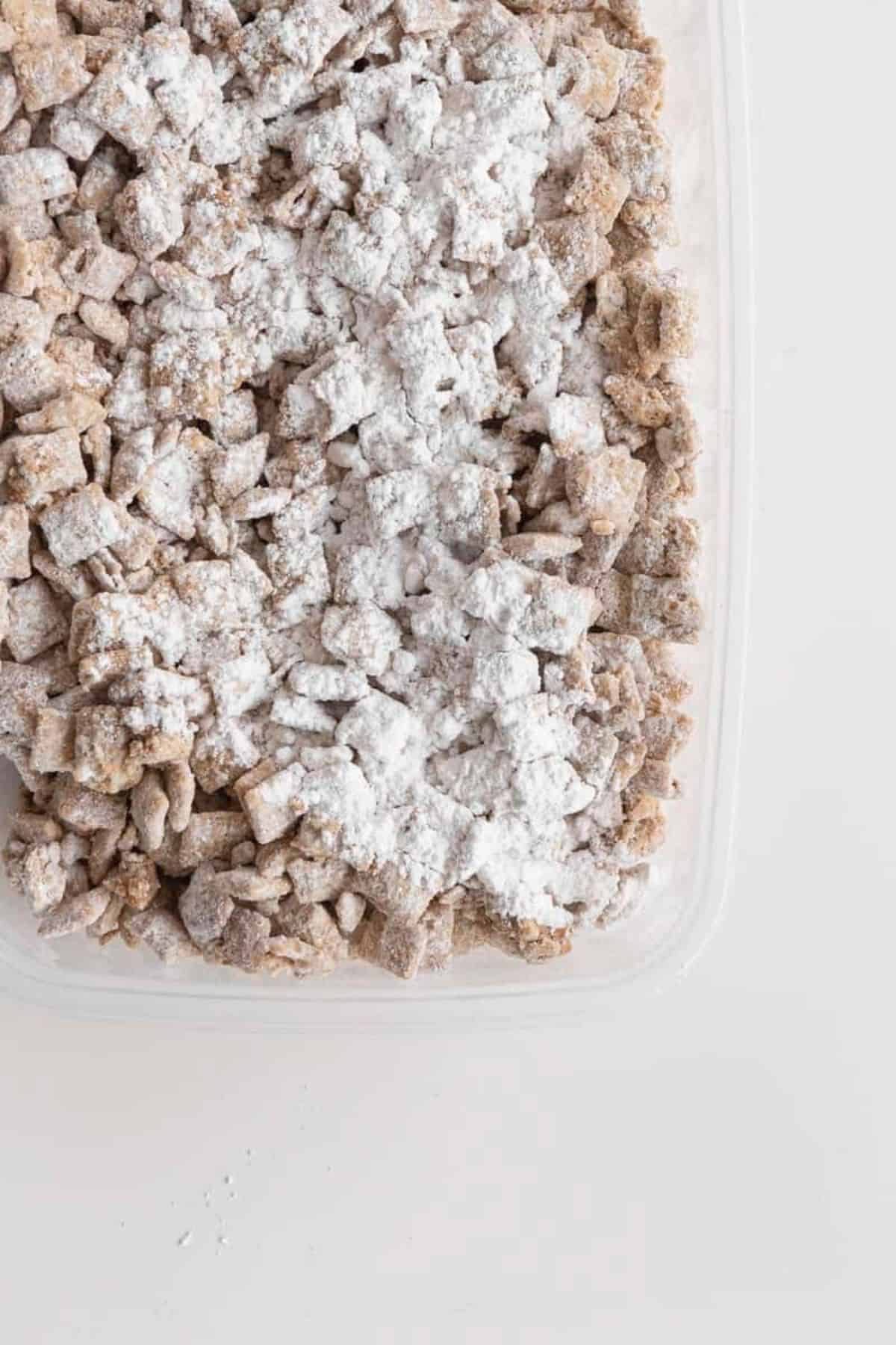 cookie butter puppy chow in bowl in tupperware