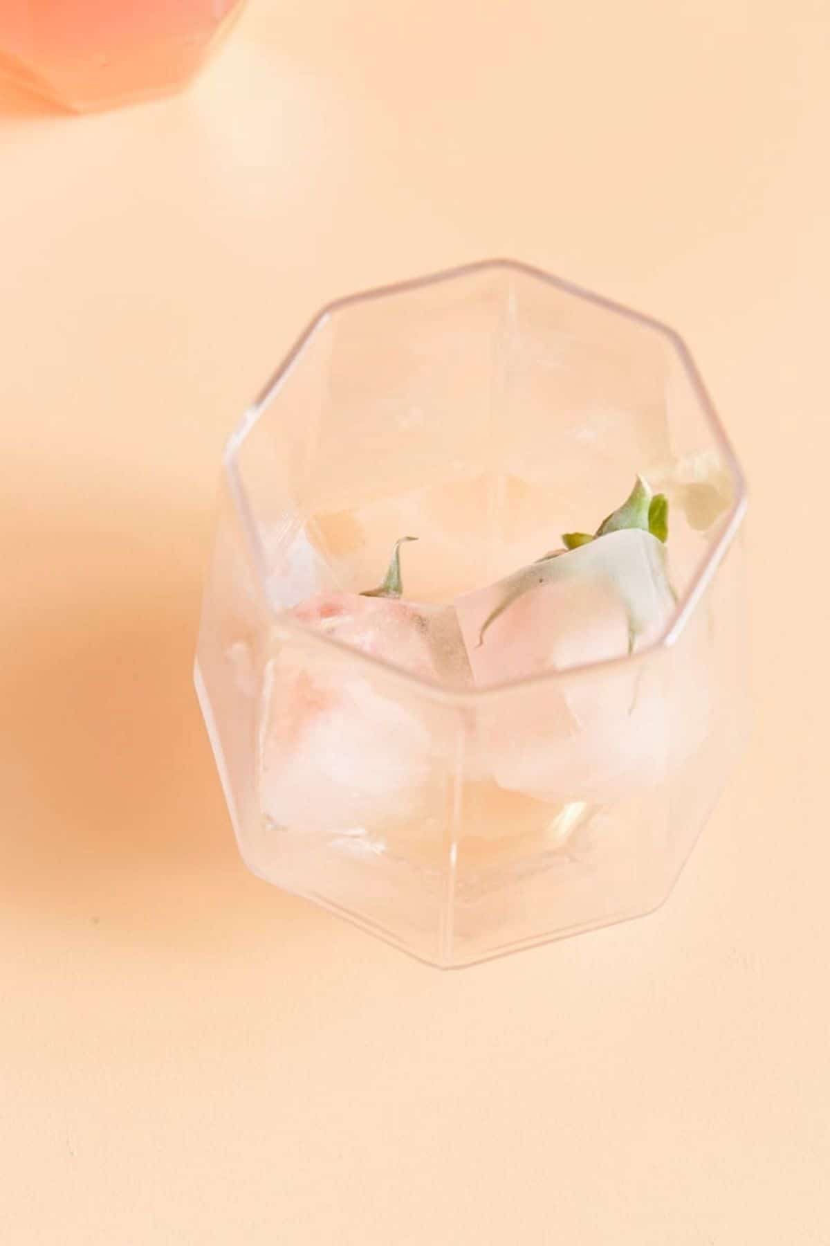 empty glass with rose ice cubes
