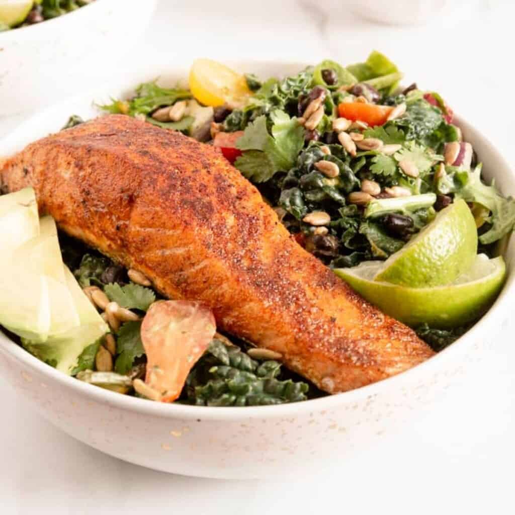 bowls of salad and dressing with salmon
