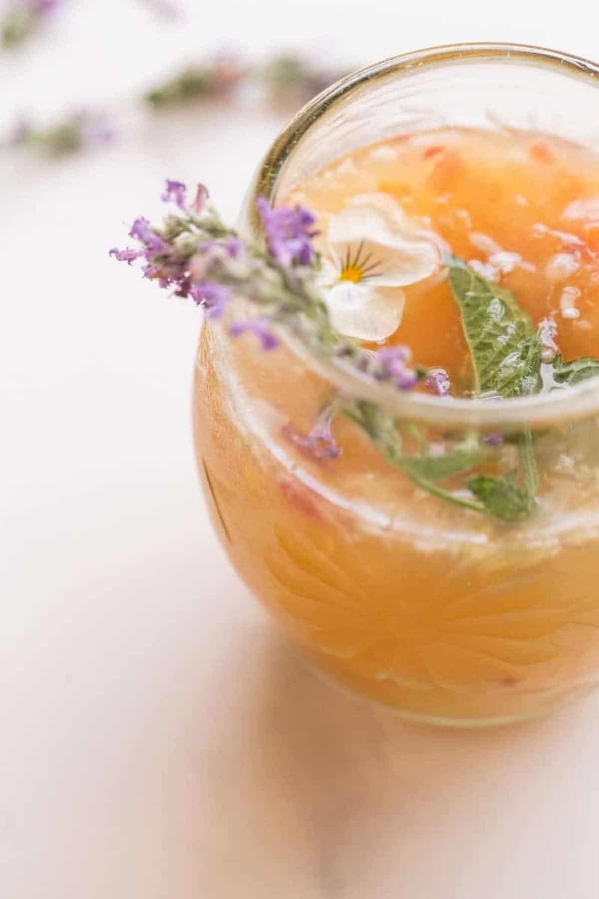 closeup of sangria in glass and edible flowers