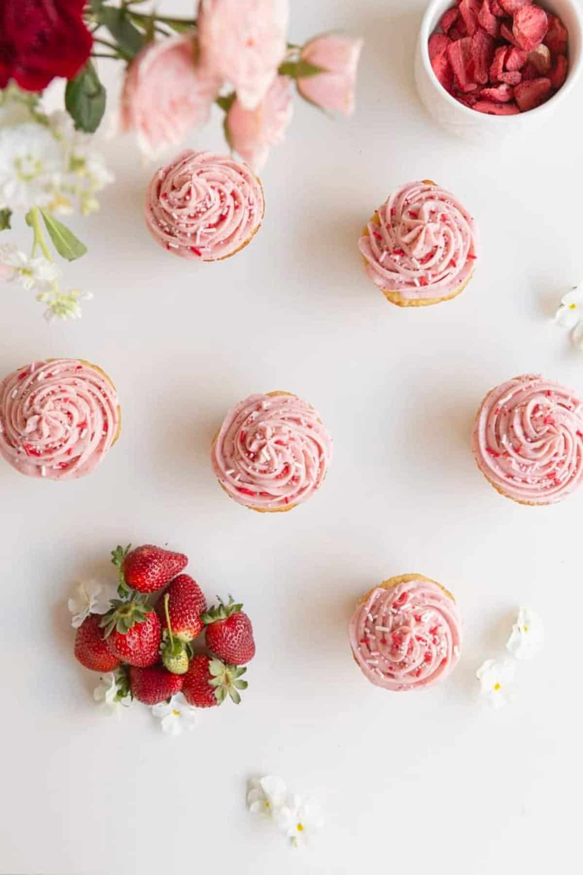 small batch vanilla cupcakes with strawberry buttercream with berries and flowers