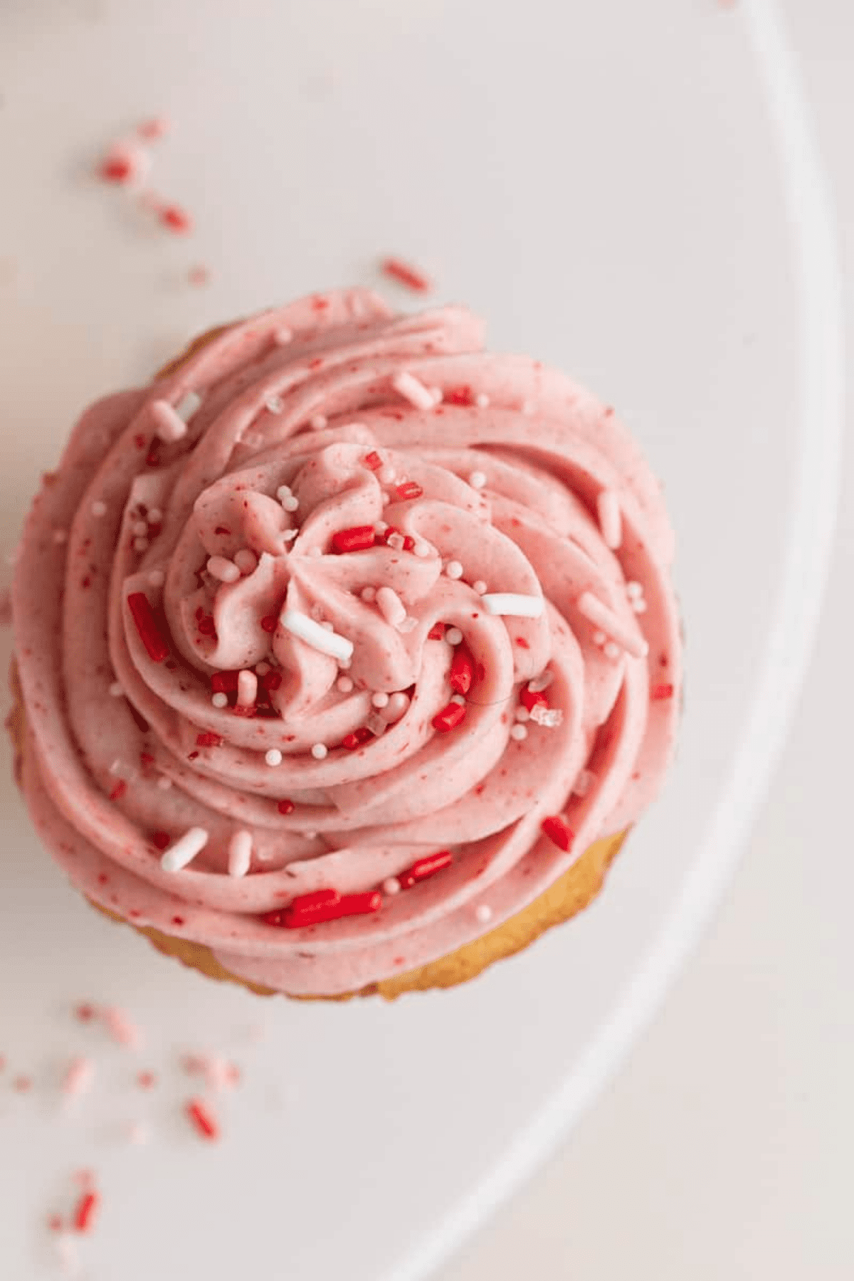 close up with of strawberry frosting with sprinkles