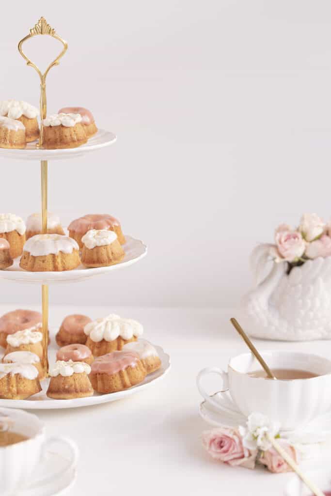 Honey Cupcakes on a cake stand with a vase and flowers