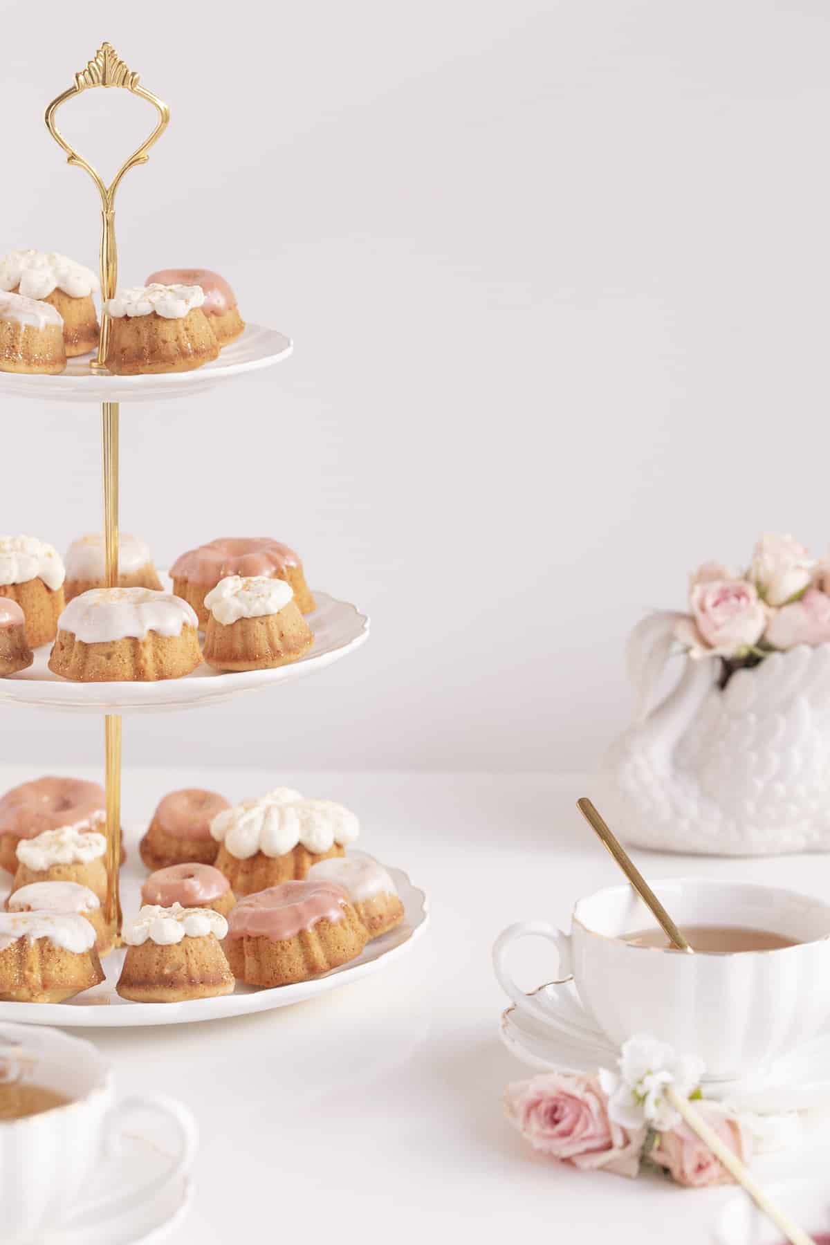 Honey Cupcakes on a cake stand with a vase and flowers
