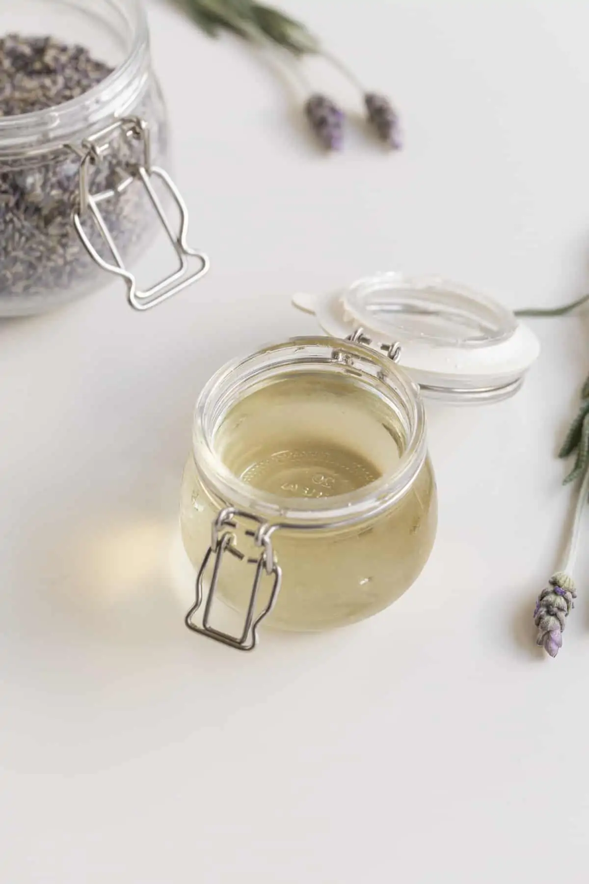 Lavender simple syrup in a jar with lavender jar and lavender flowers
