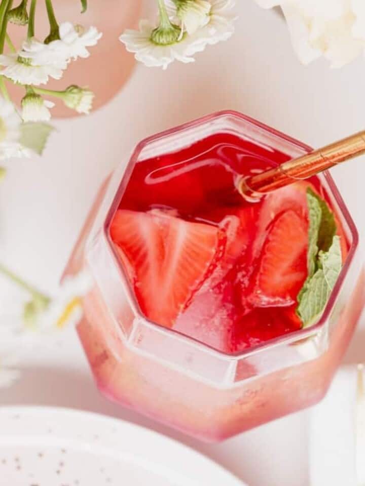Rosé Sangria in a pitcher filled with berries and lemon slices