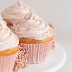 strawberry cupcakes with filling on a cake stand with flowers