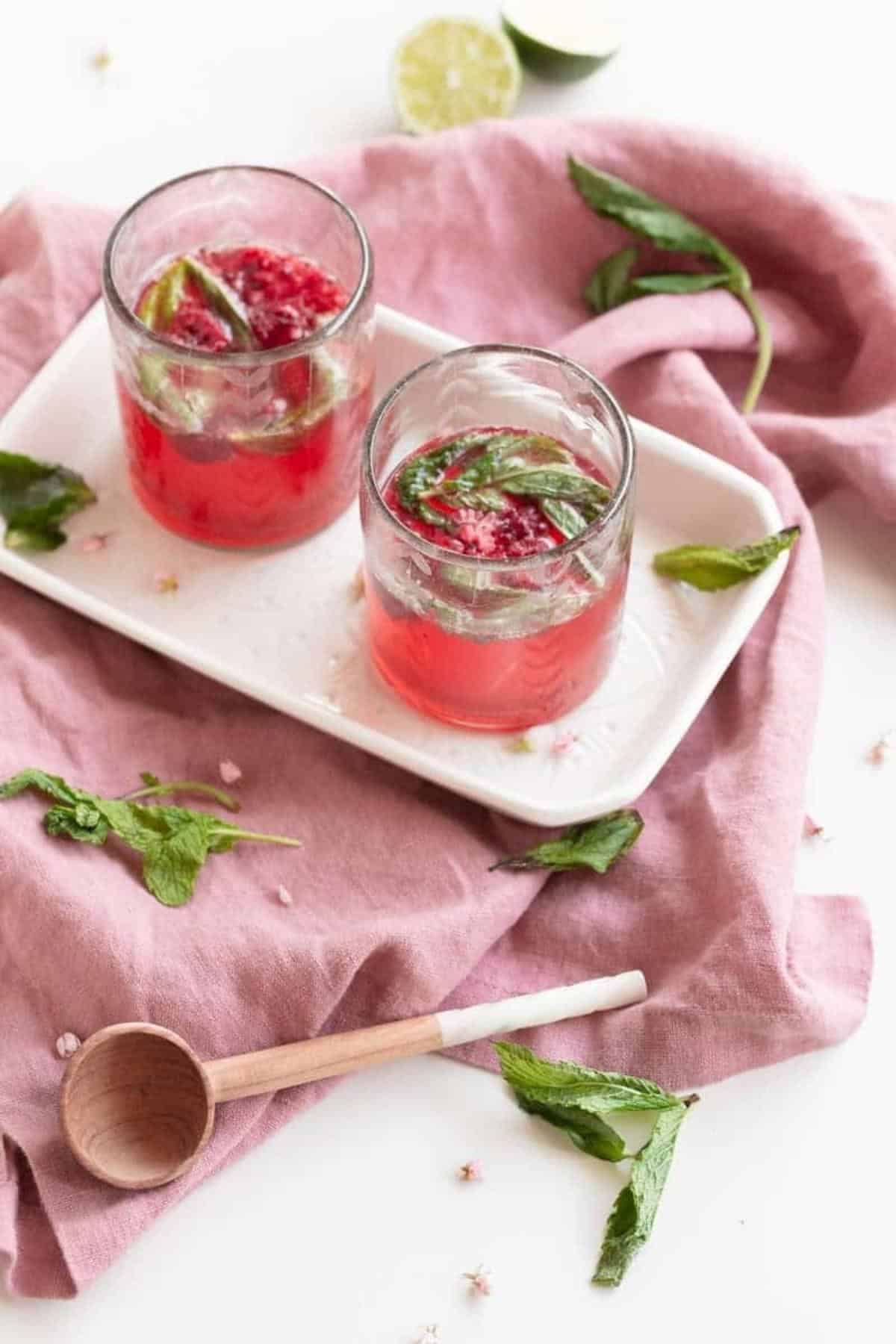 raspberry mojio with mint and limes on tray