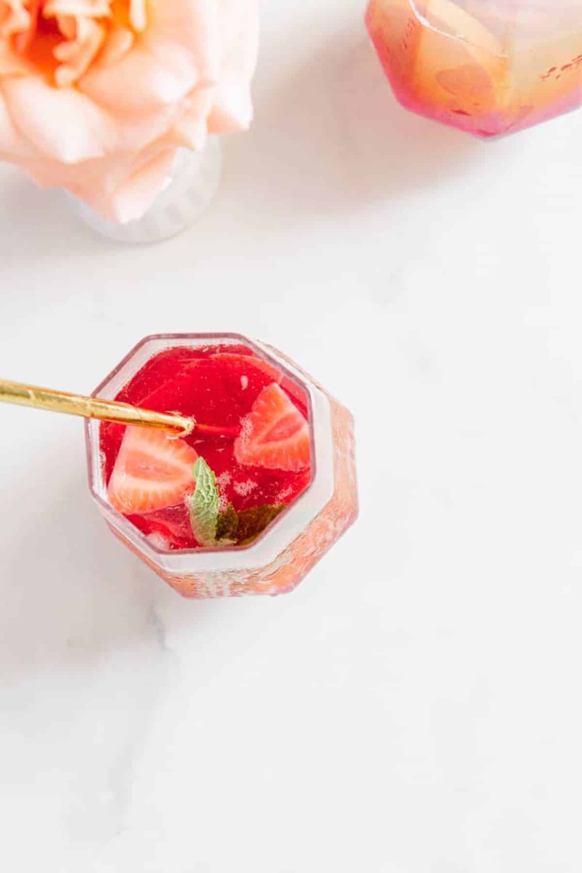 rose sangria in glasses with strawberries on top and mint