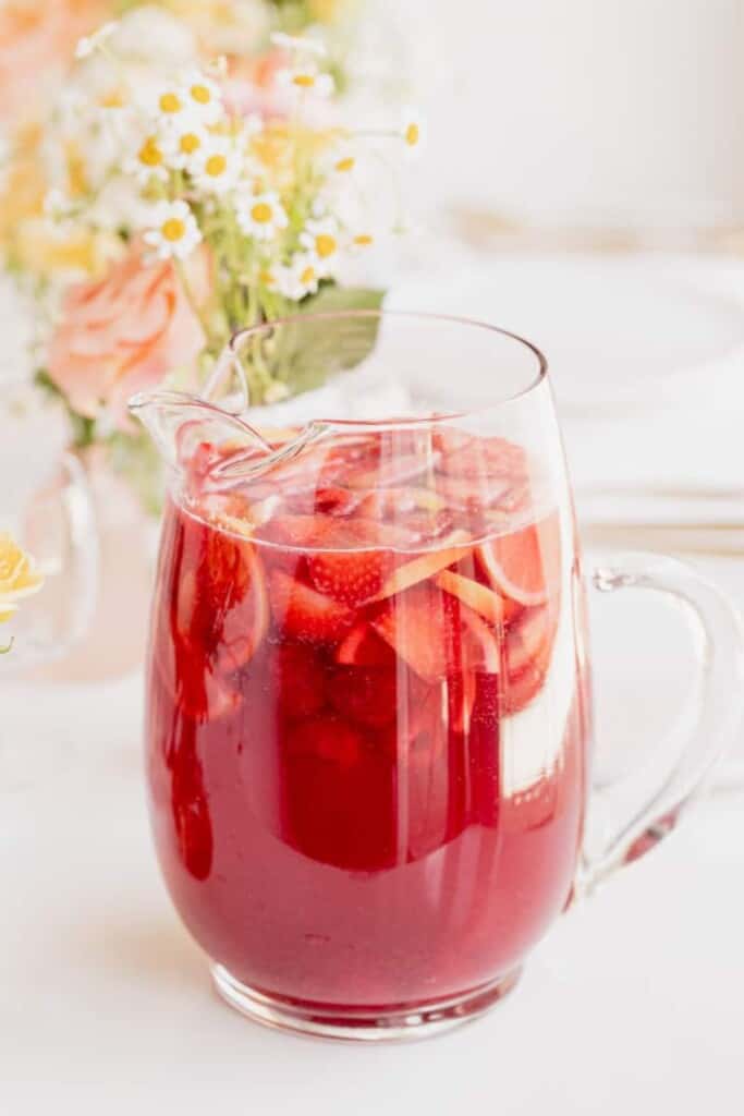 Rosé Sangria in a pitcher filled with berries and lemon slices