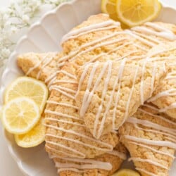 lemon glaze on scones on a plate with lemon slices