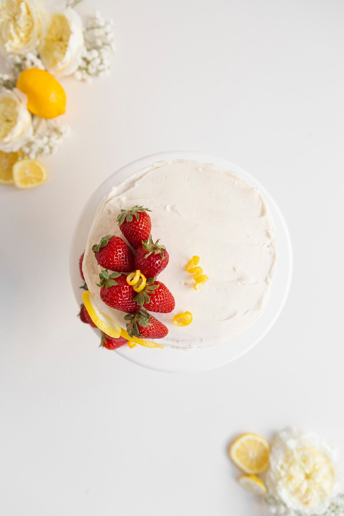 strawberry lemon cake from above with strawberries and flowers