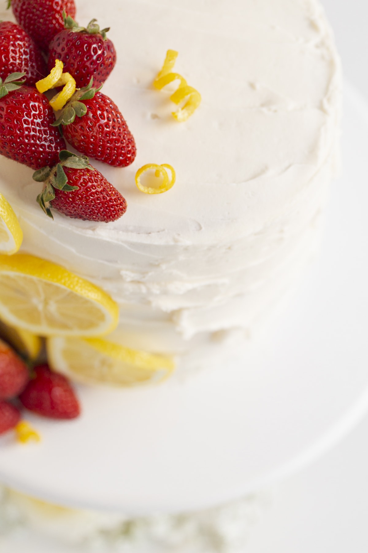 cake with strawberry filling topped with strawberries and lemon slices