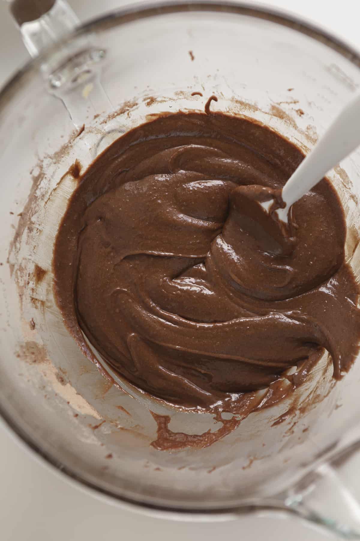 brownie batter in a bowl with a white rubber spatula