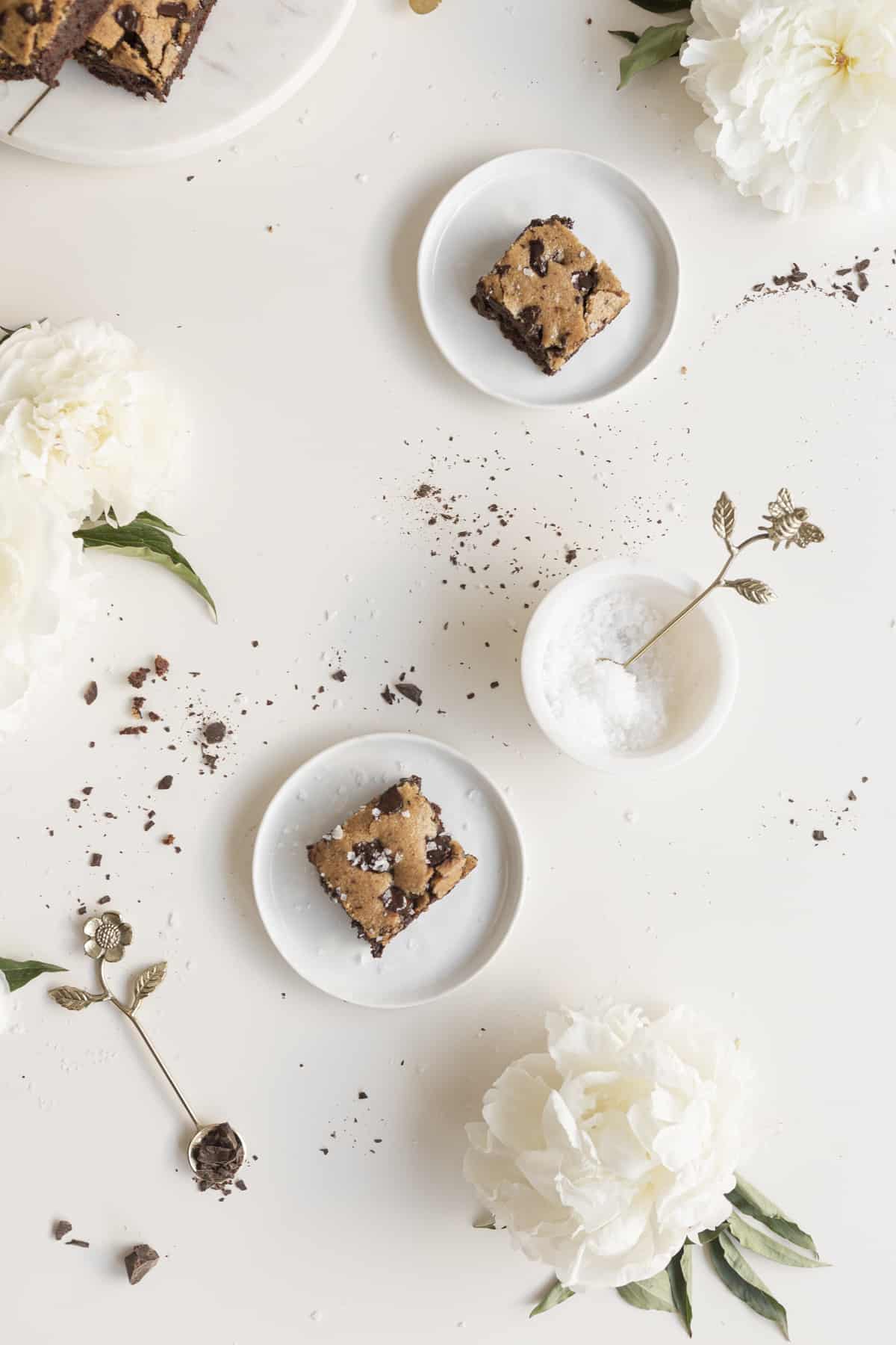 brookies on plates with chocolate in a white bowl and white peonies on a white surface