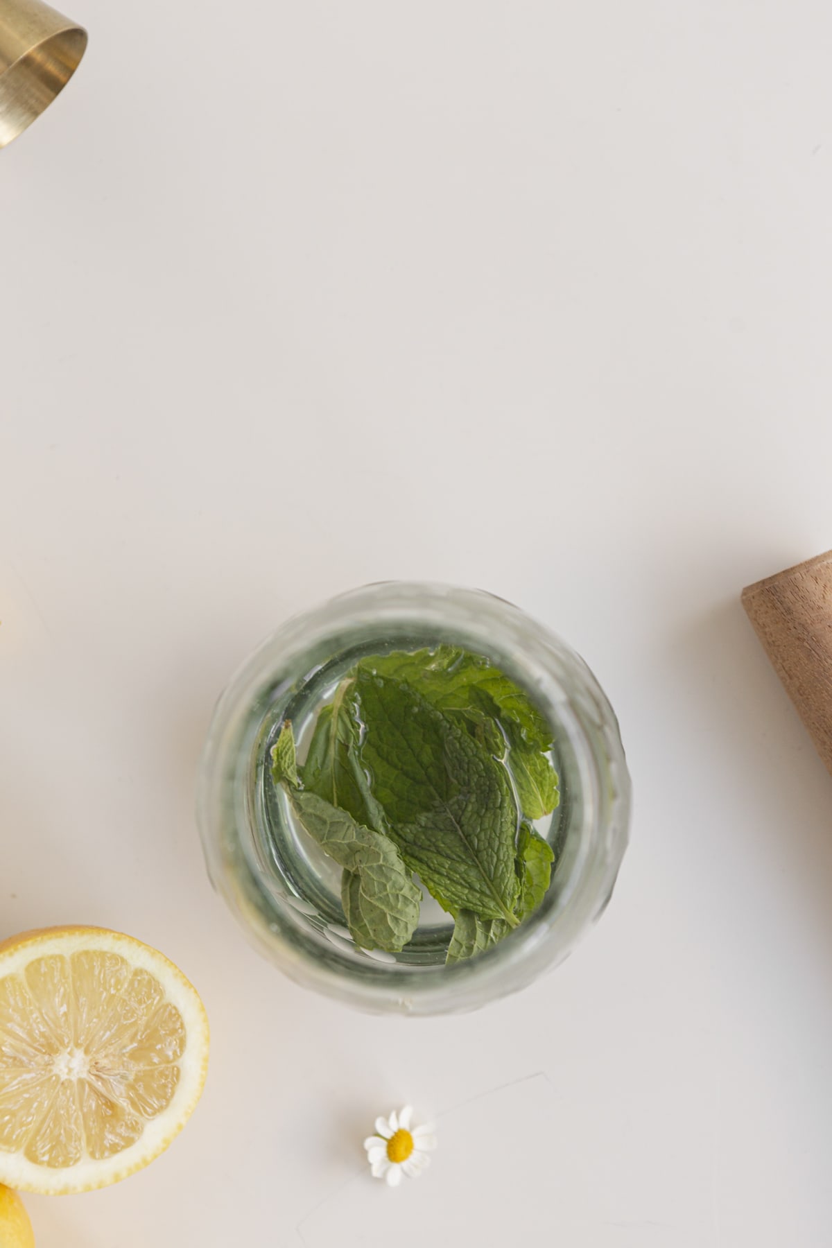 mint leaves in liquid in a cup to be muddled