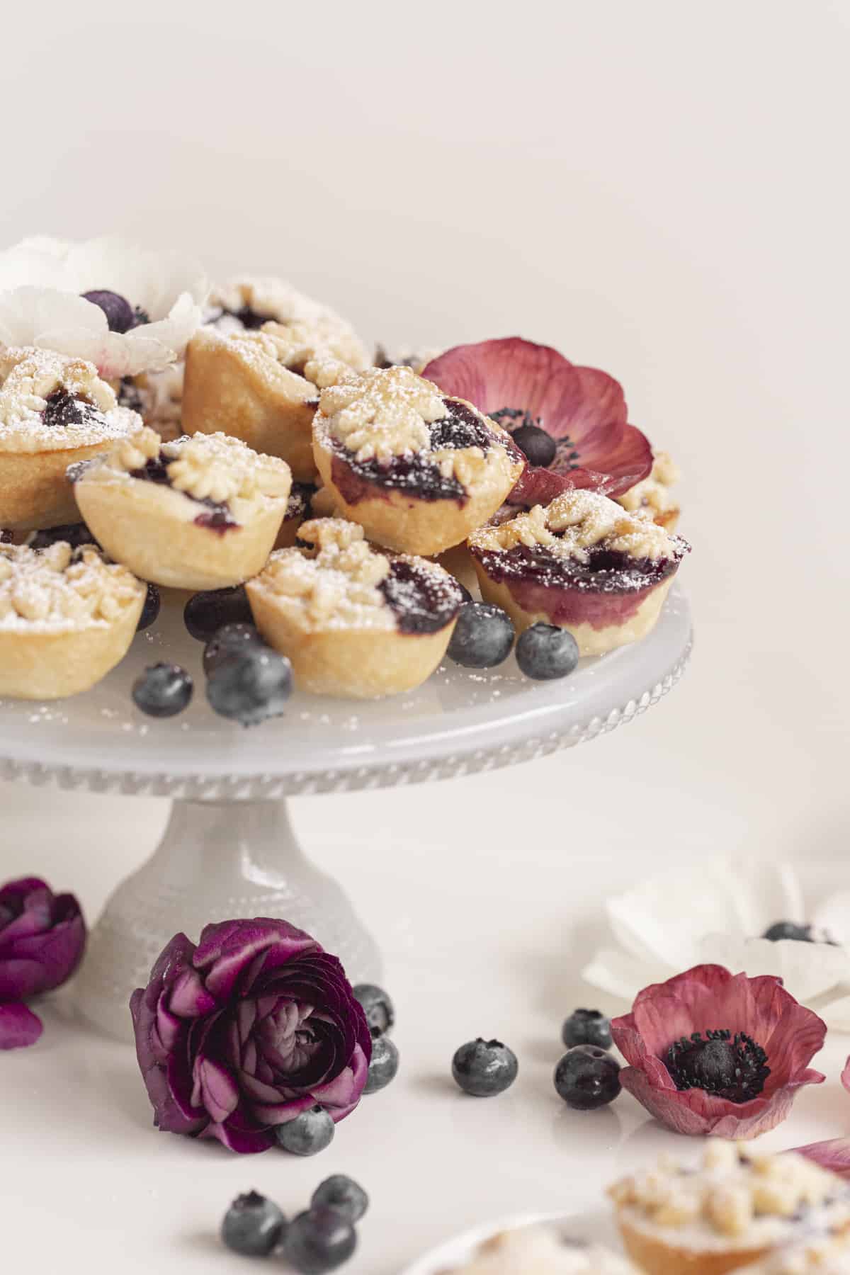 mini pies on a blue cake stand with flowers