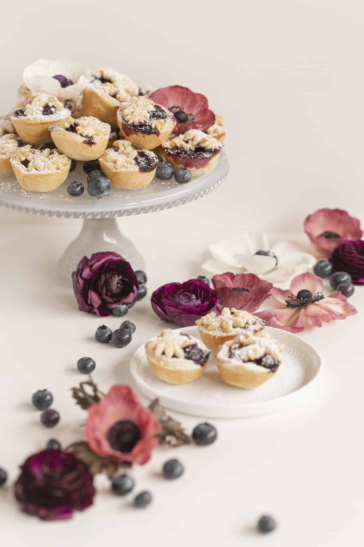 mini pies on a cake stand and plate with flowers