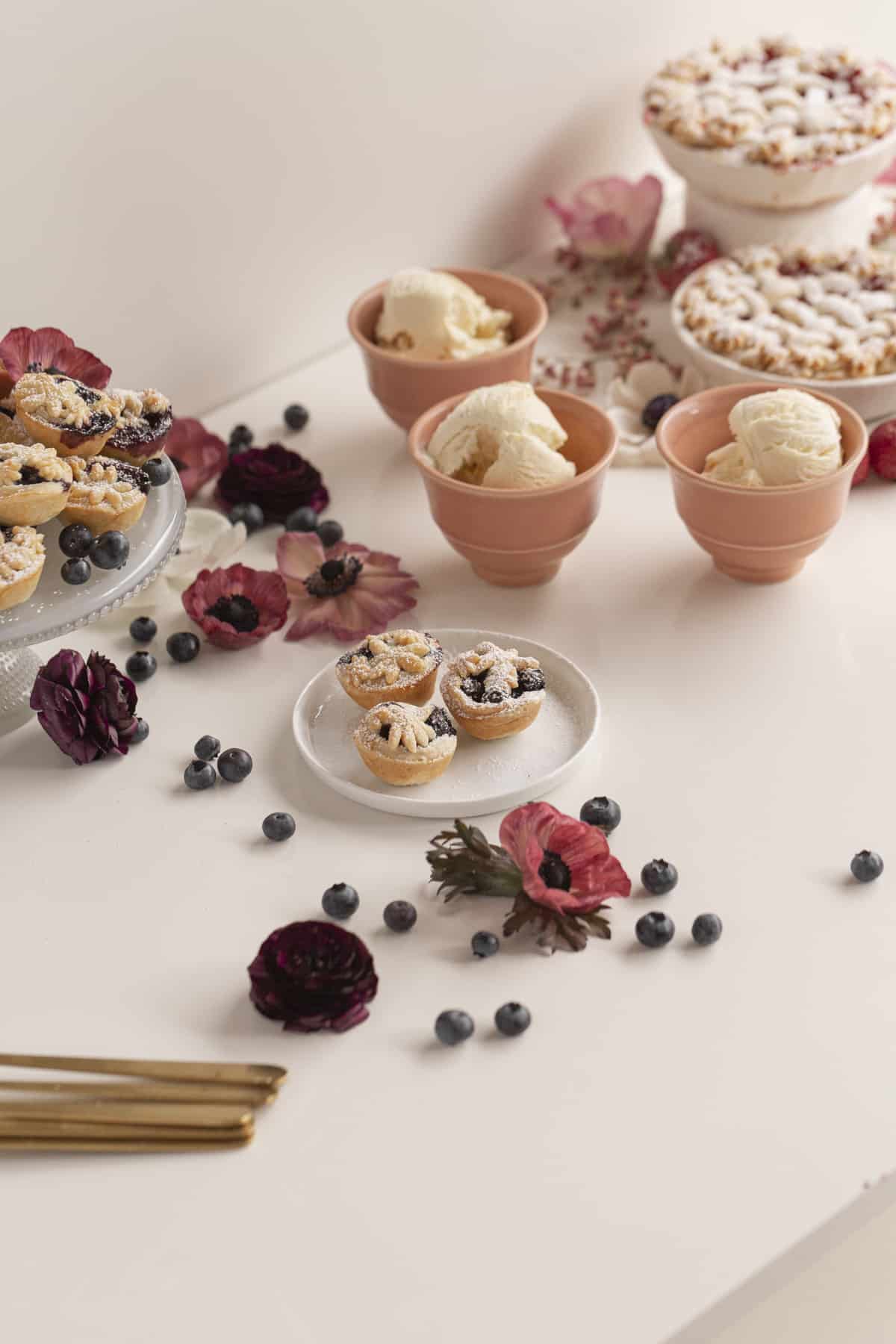 mini pies on a cake stand with ice cream in cups