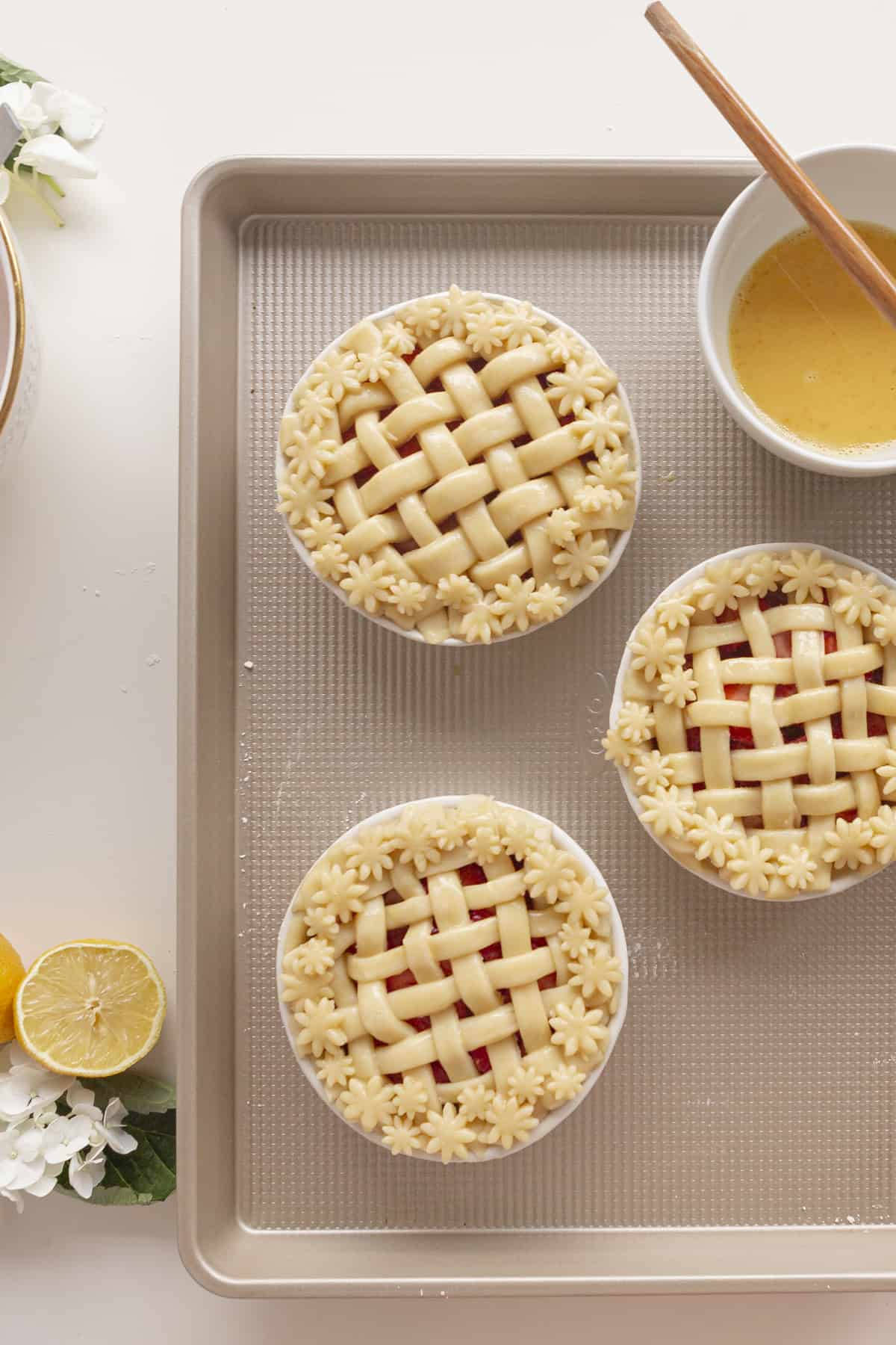lattice top on pies with egg wash on a baking sheet