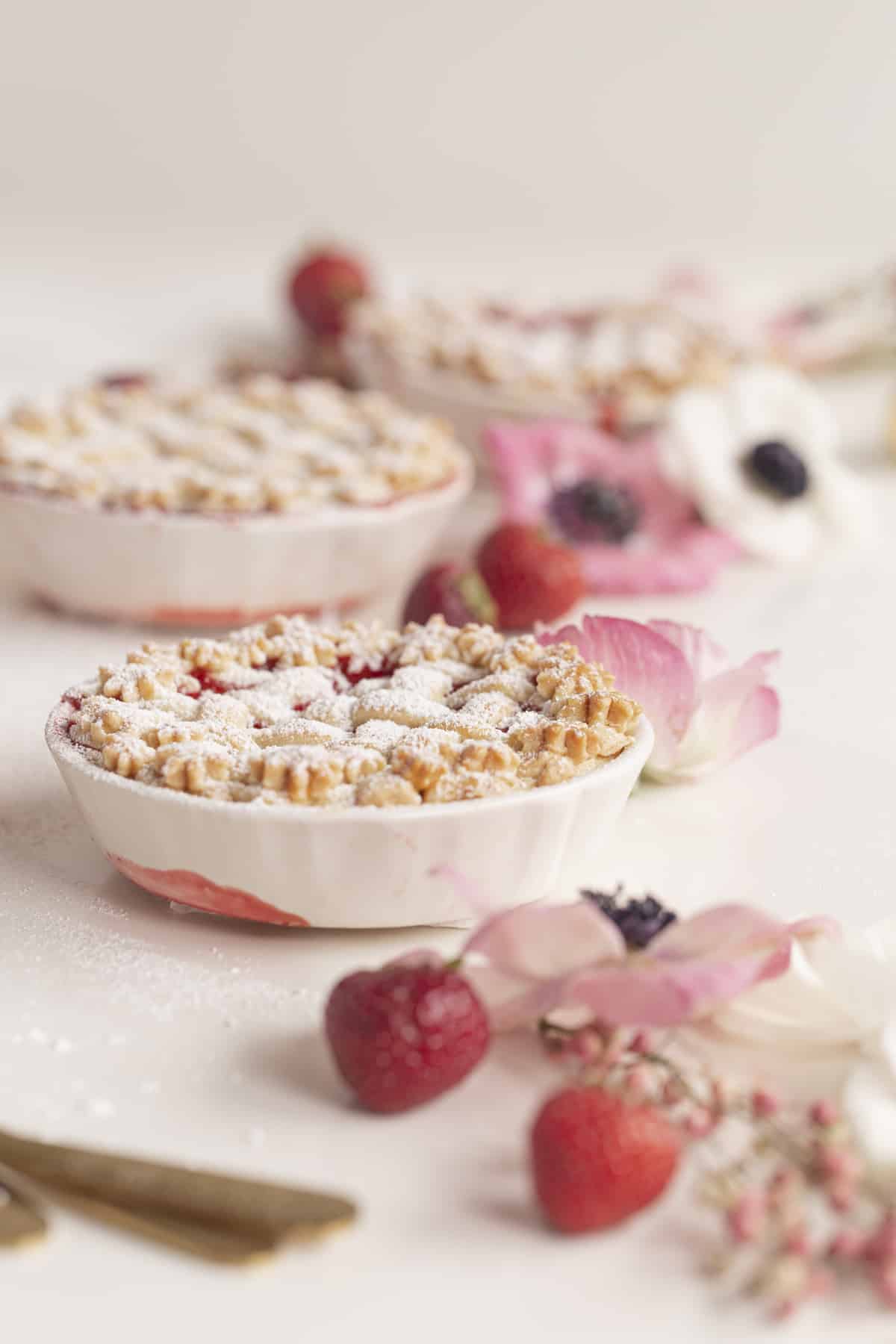 three mini pies with strawberries and flowers