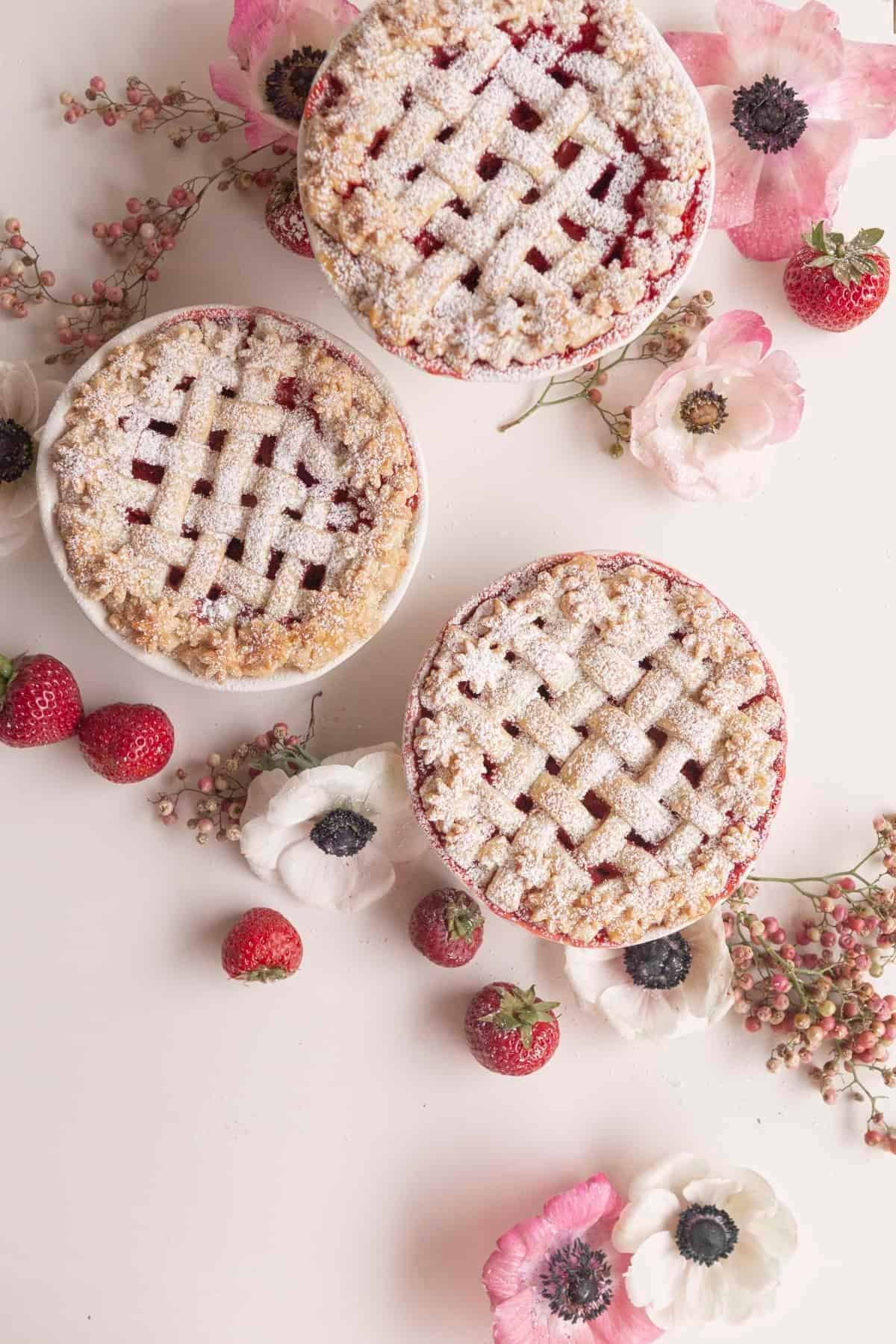 strawberry pies on a white surface with flowers