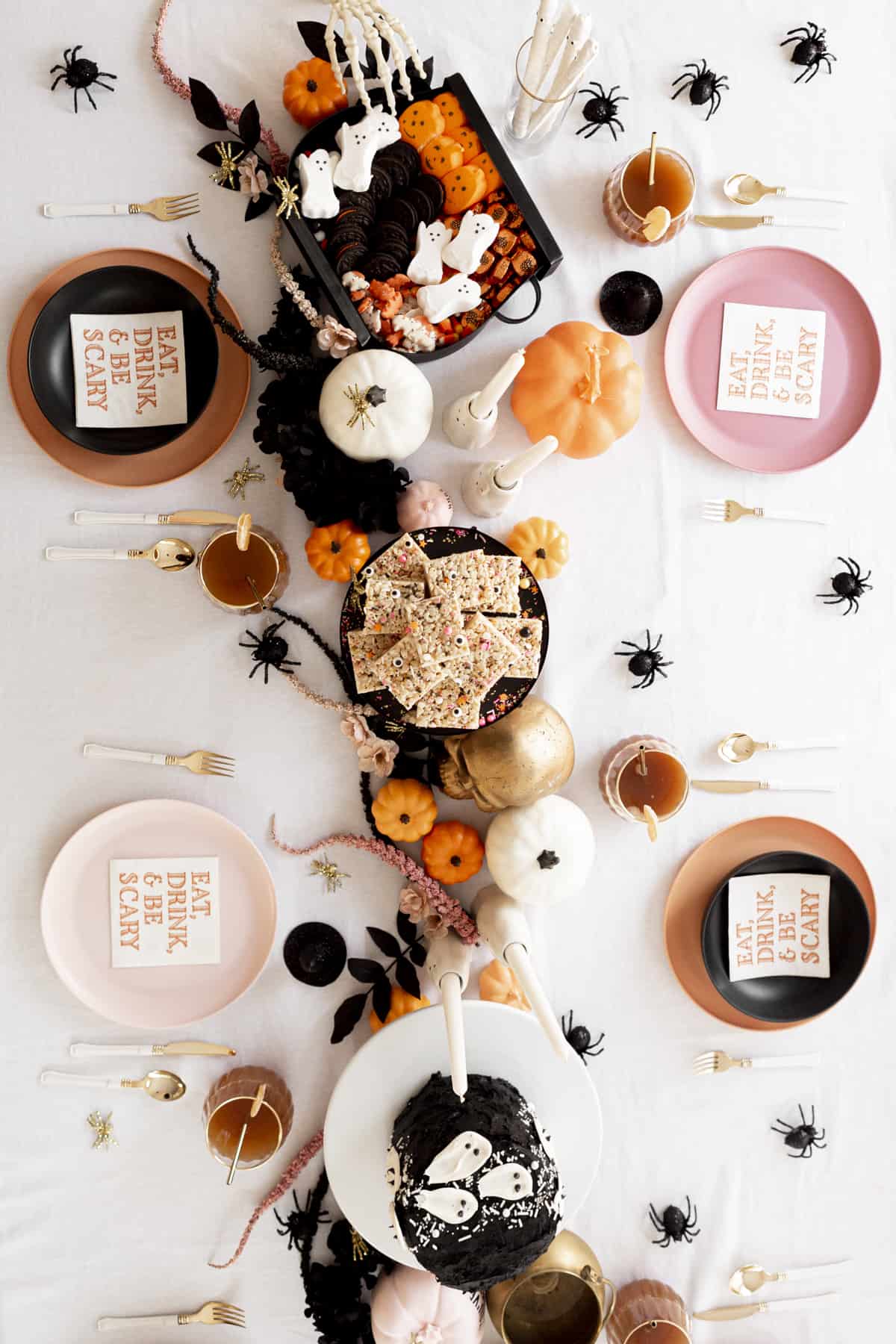 halloween table decor with food on cake stands and faux flowers