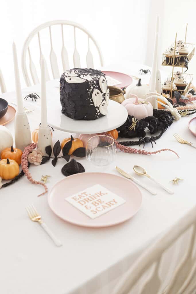 black velvet cake with ghost candies on a halloween decorated table