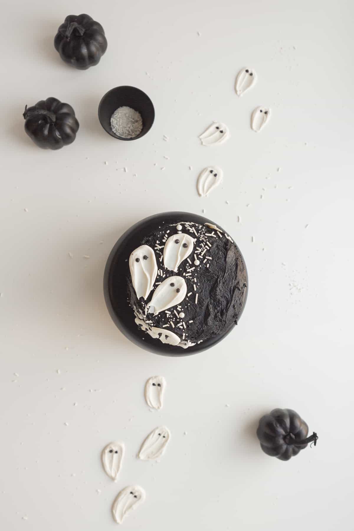 black velvet cake with white candy ghosts with candy ghosts on table