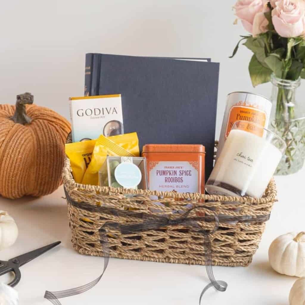 boo basket with wine, candle, blanket, glasses, and kitchen towel