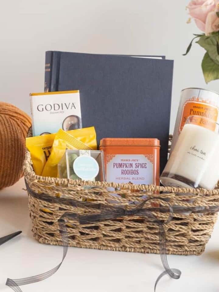 boo basket with wine, candle, blanket, glasses, and kitchen towel