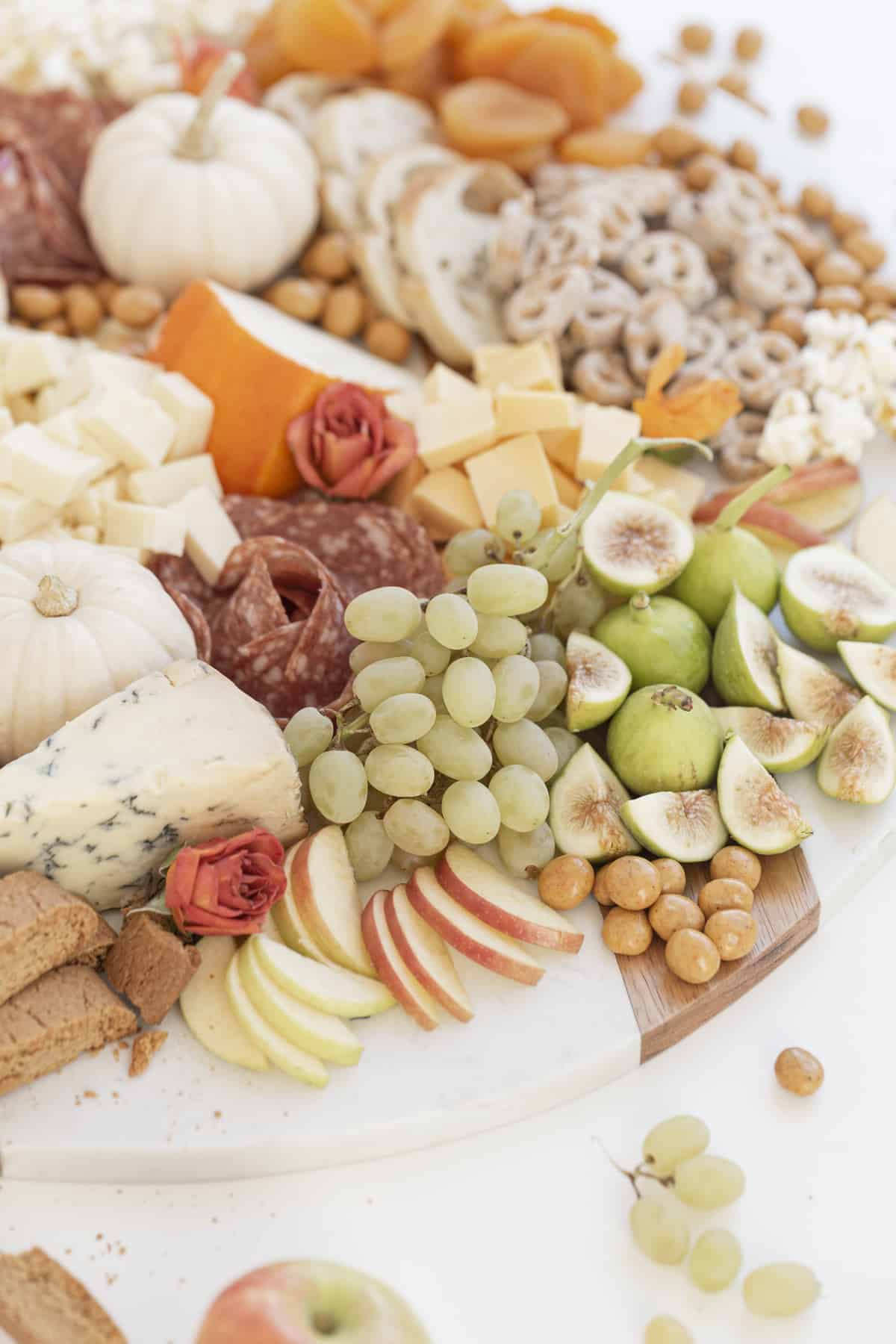 fruit cheese and salami on a board with edible roses