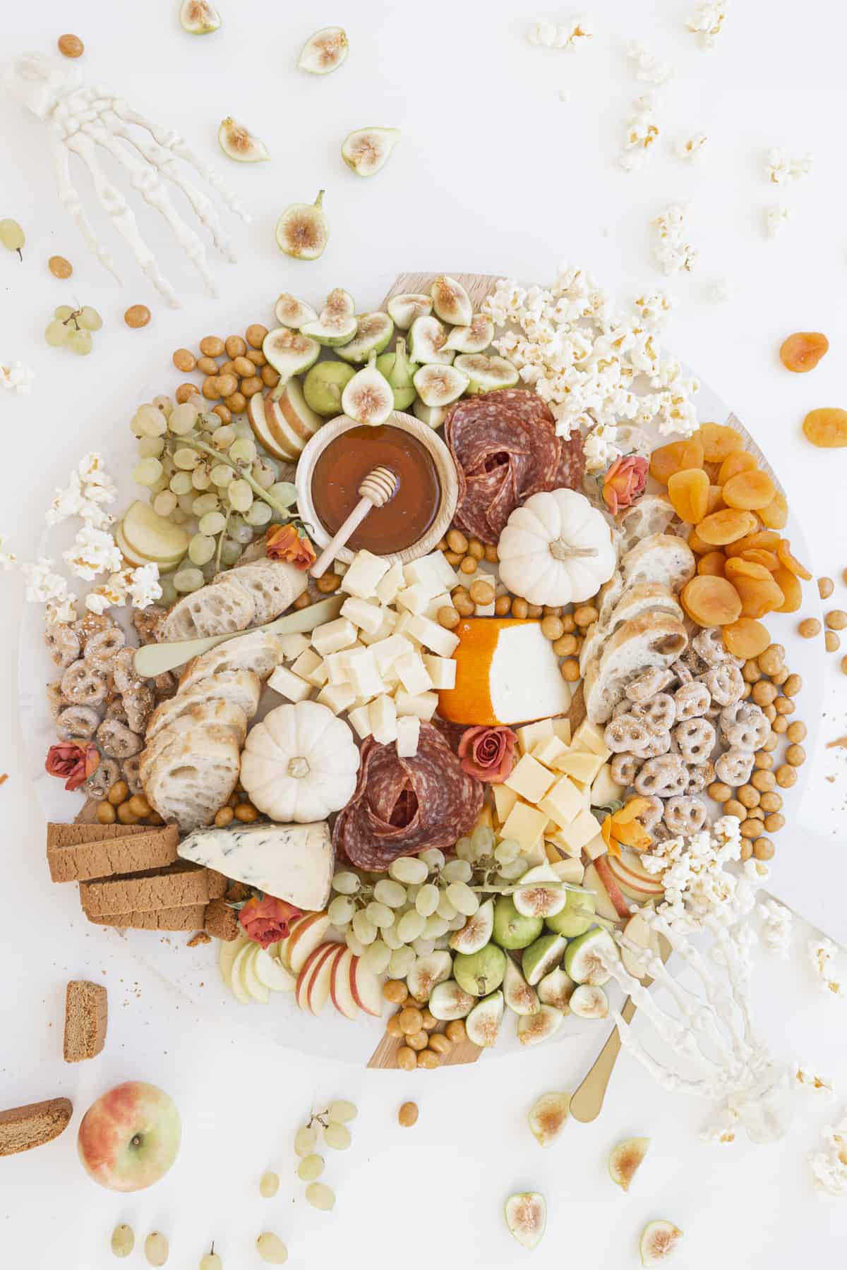 halloween charcuterie board with pumpkins and skeleton hands