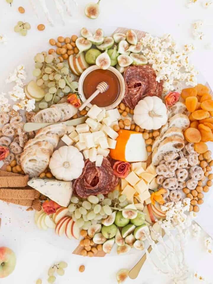 halloween charcuterie board with pumpkins and skeleton hands